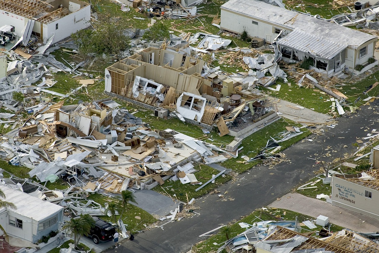 Damaged houses and infrastructure stand after a hurricane destroys a neighborhood.