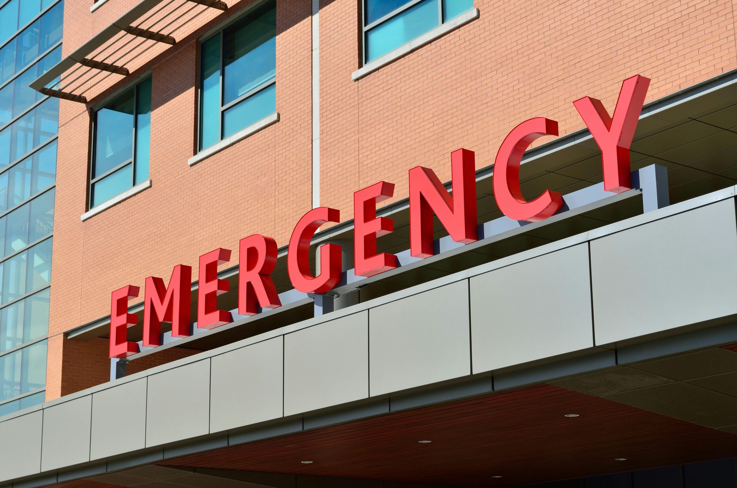 An emergency sign outside of a red brick building.
