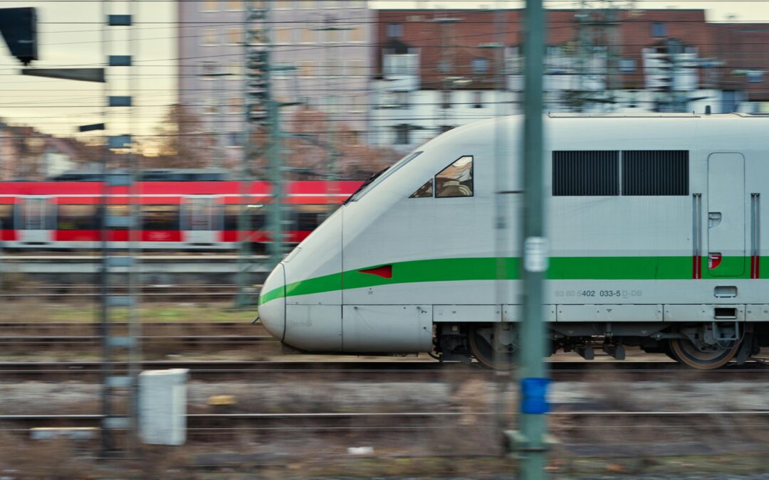 A high-speed locomotive moves along train tracks.