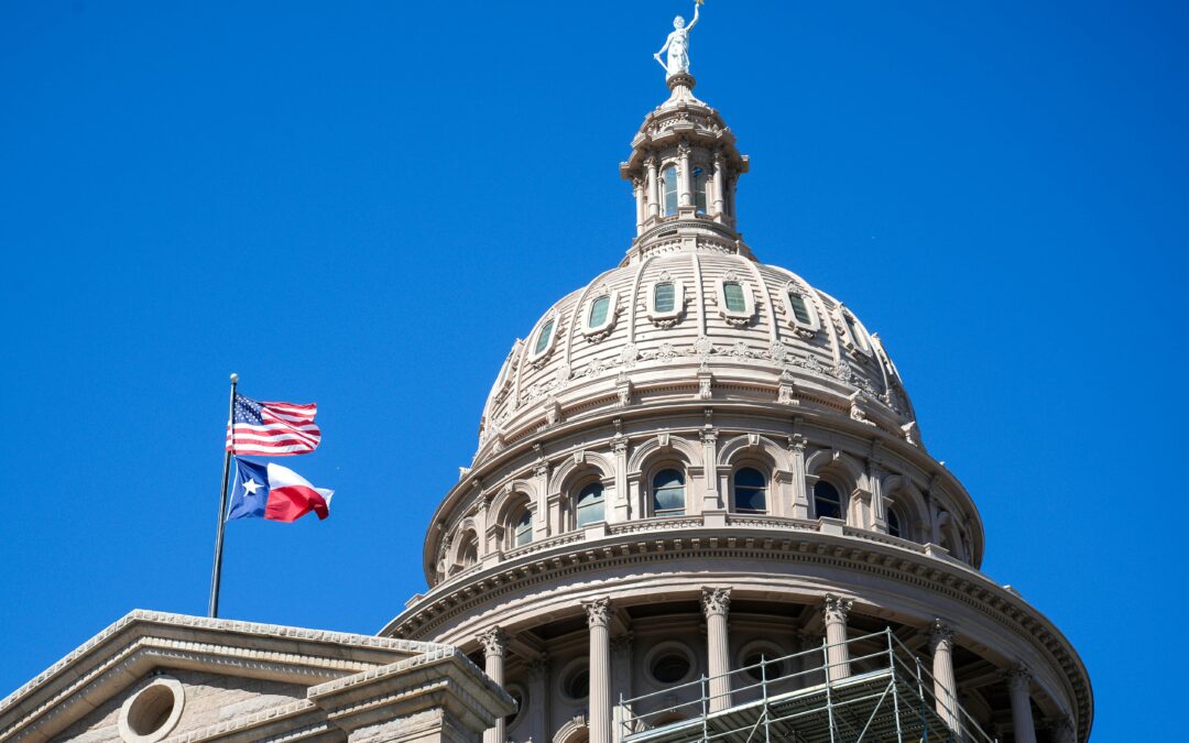 The Texas Capitol building with the American and Texas flags flying beneath.