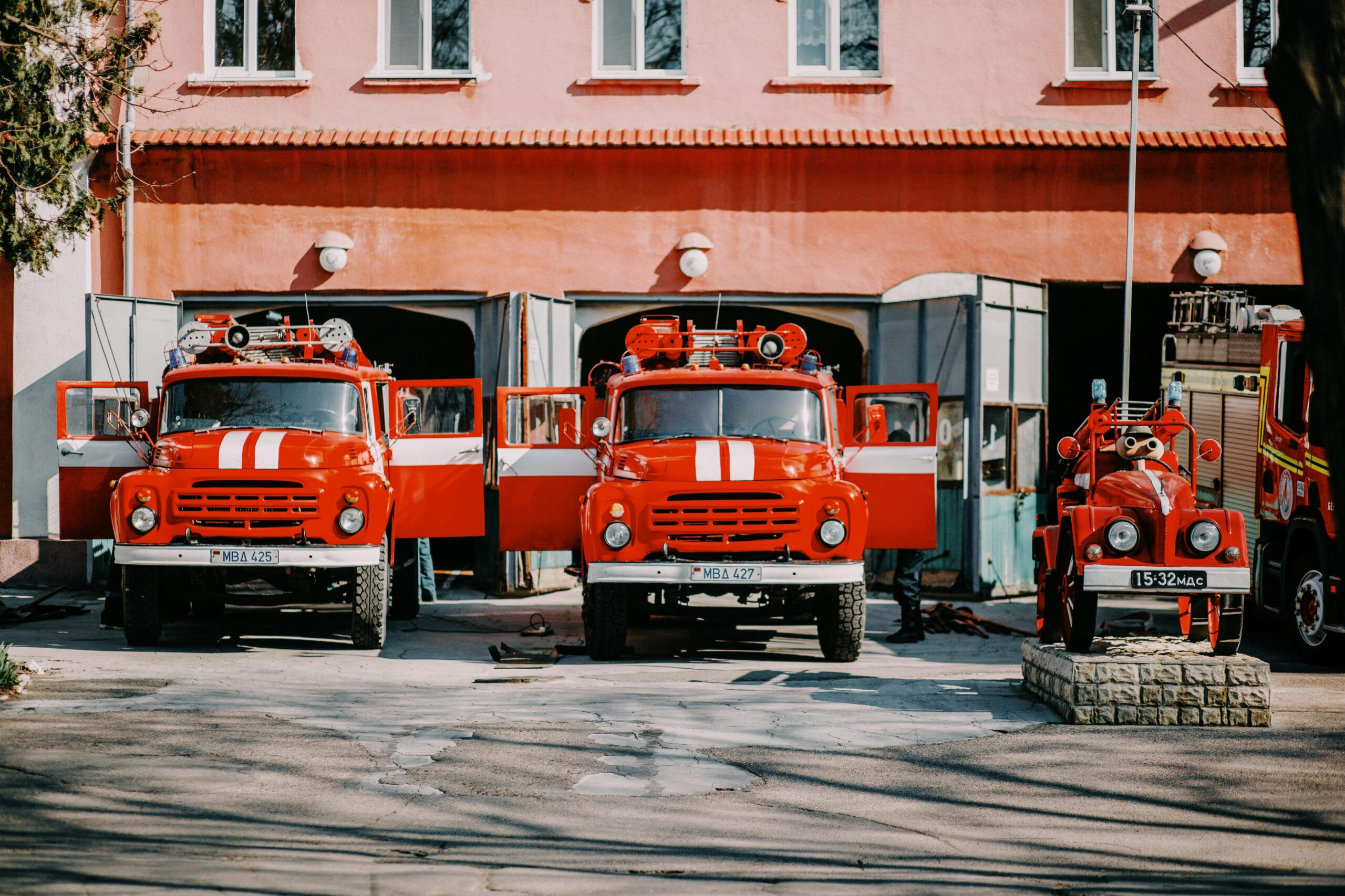 Two fire trucks in front of a fire station.