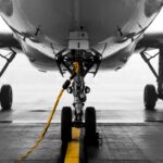 The landing gear and the belly of an airplane on the tarmac.
