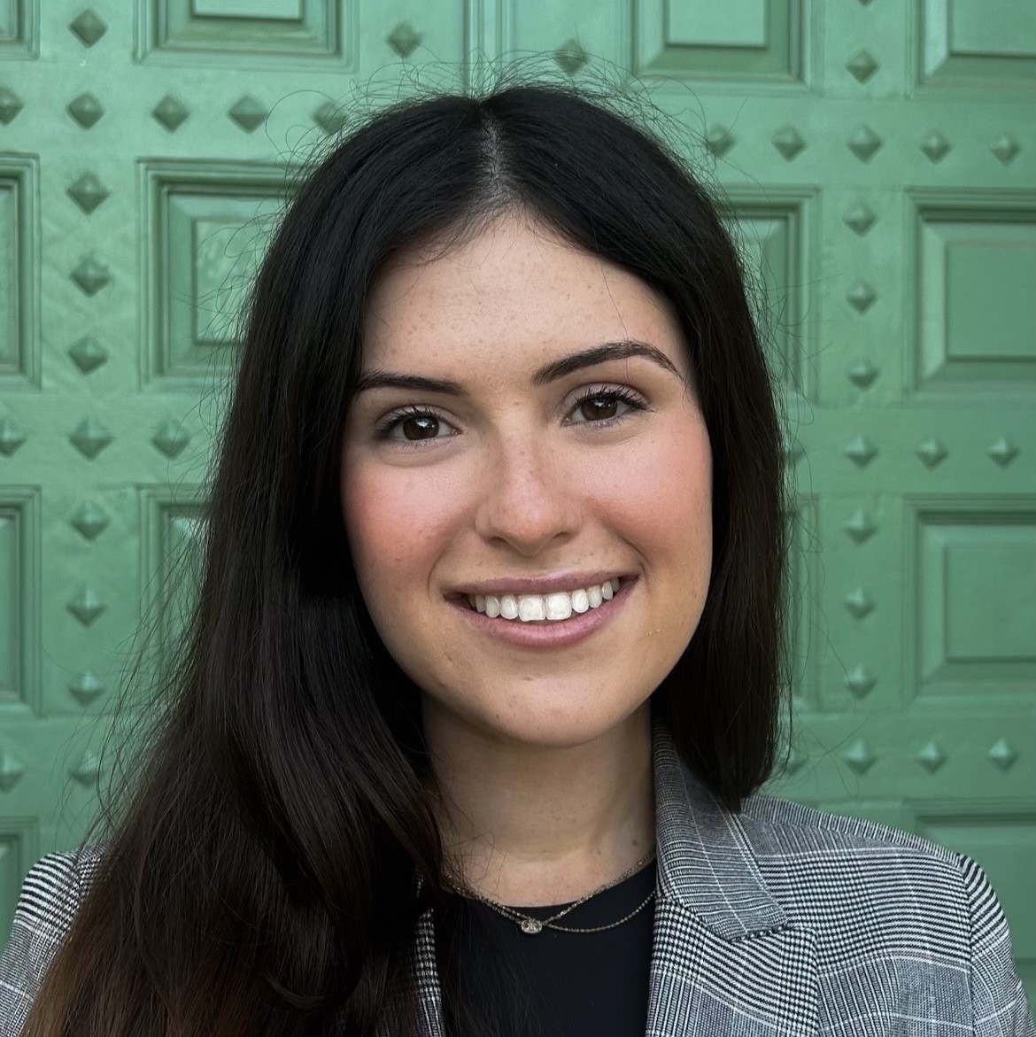 A portrait of Tracy Baker before a green door.