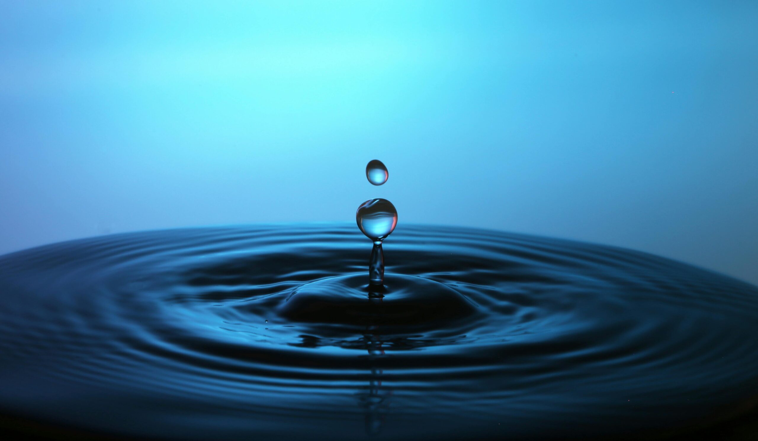 A water droplet in a pool of water.