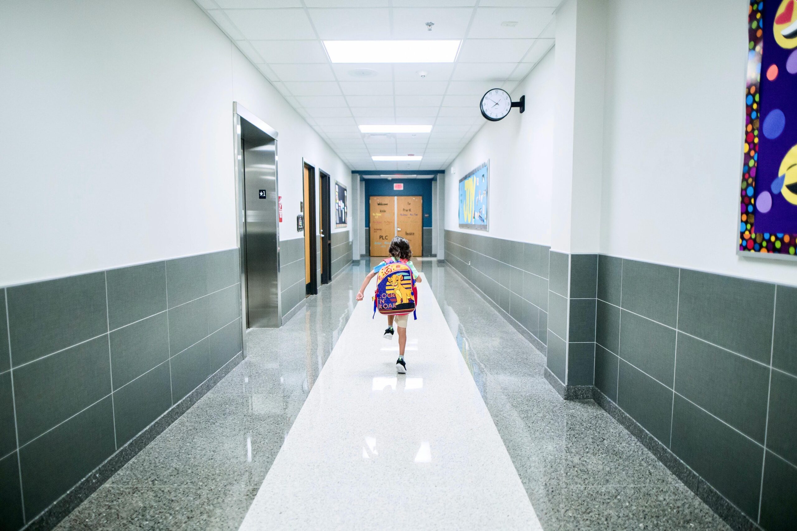 A child runs through a school hallway.