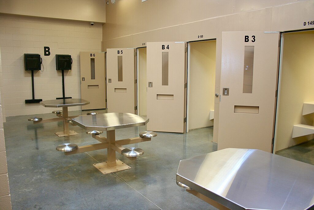 clark-county-jail-project The interior of a jail with several cell doors and tables.