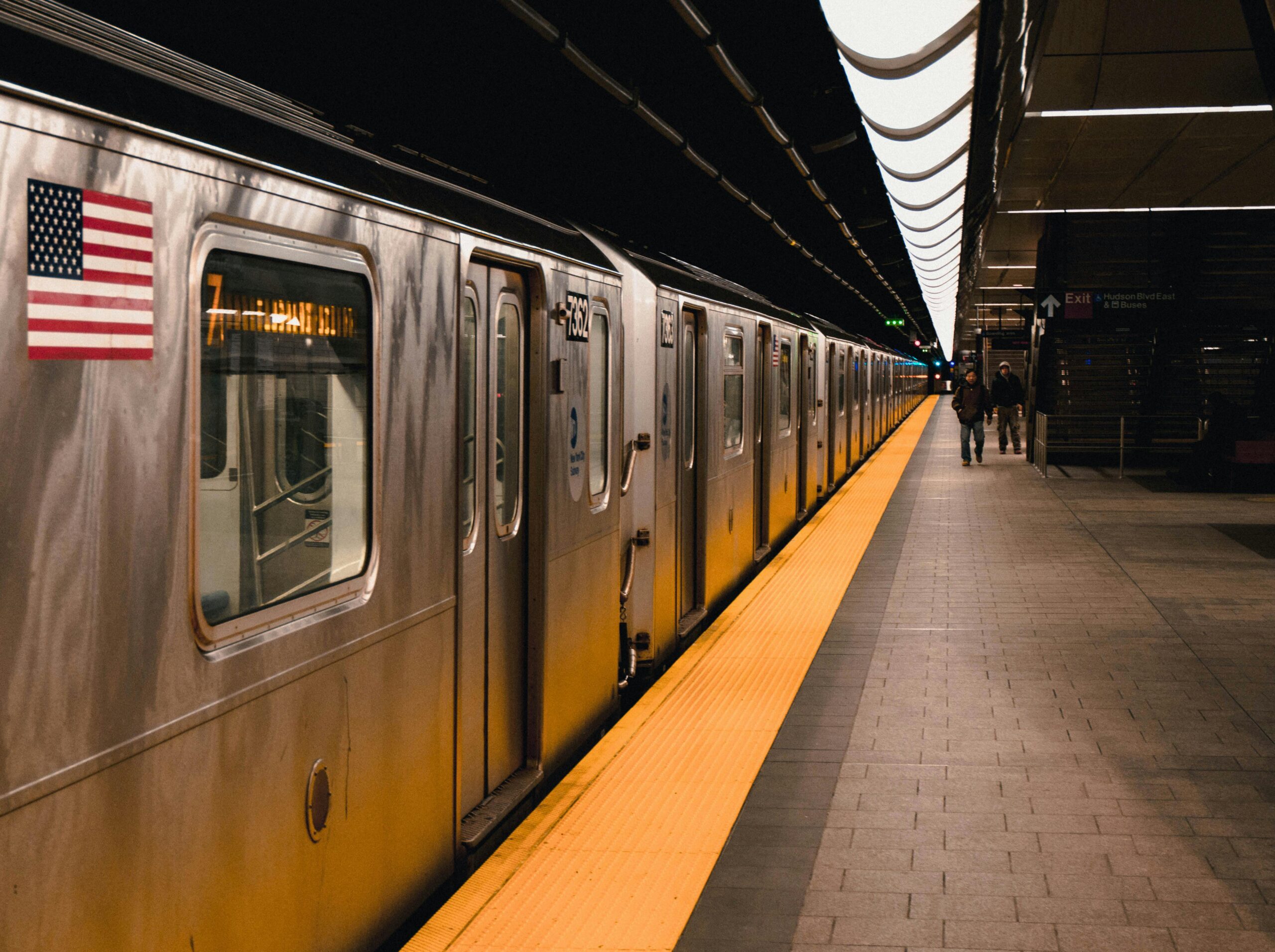 new-york-transportation-transit-funding-2026 A subway station with a train and passengers in New York City.