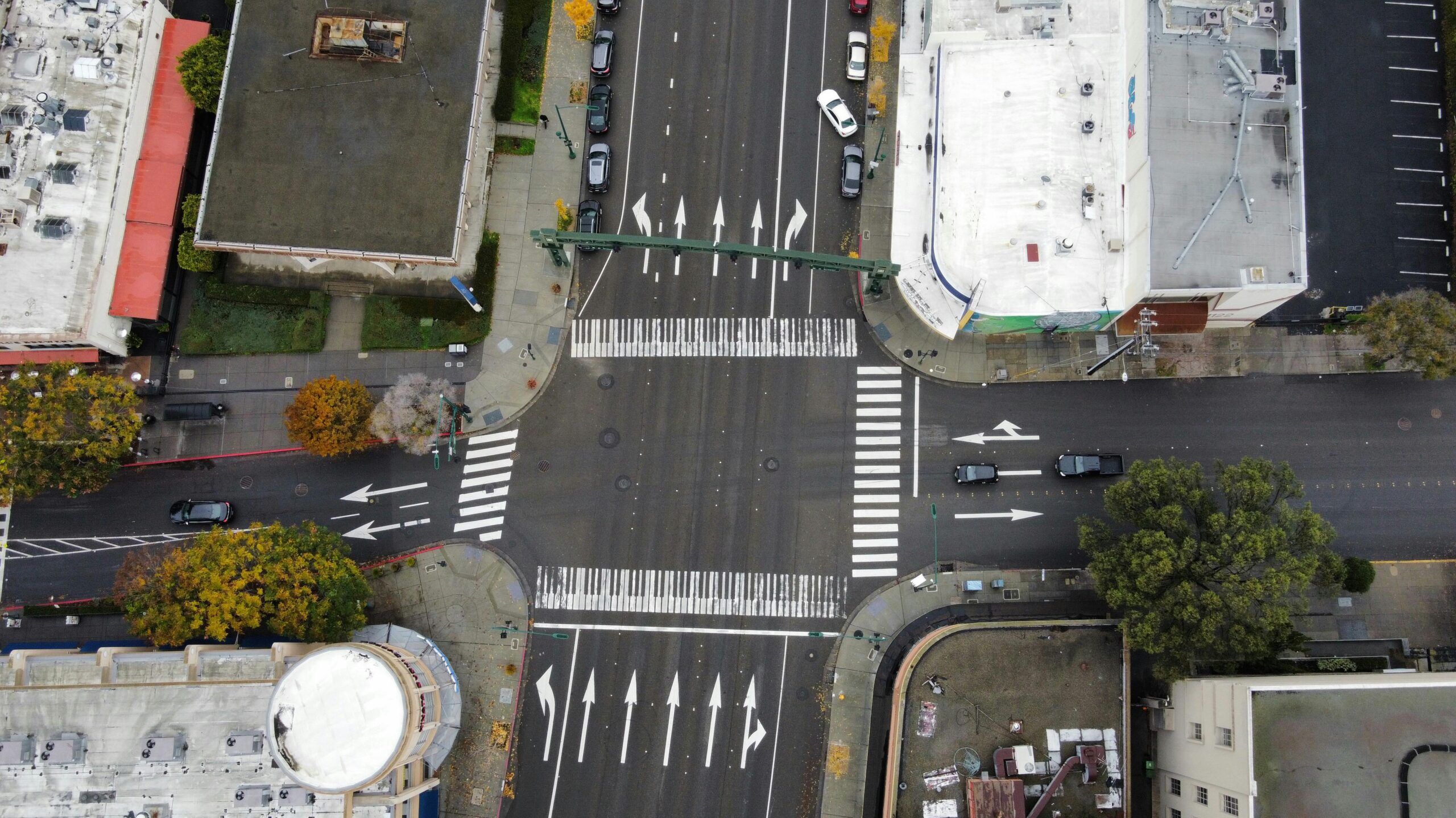usdot-1b-ss4a-2026 An aerial view of a roadway intersection with cars and pedestrians.